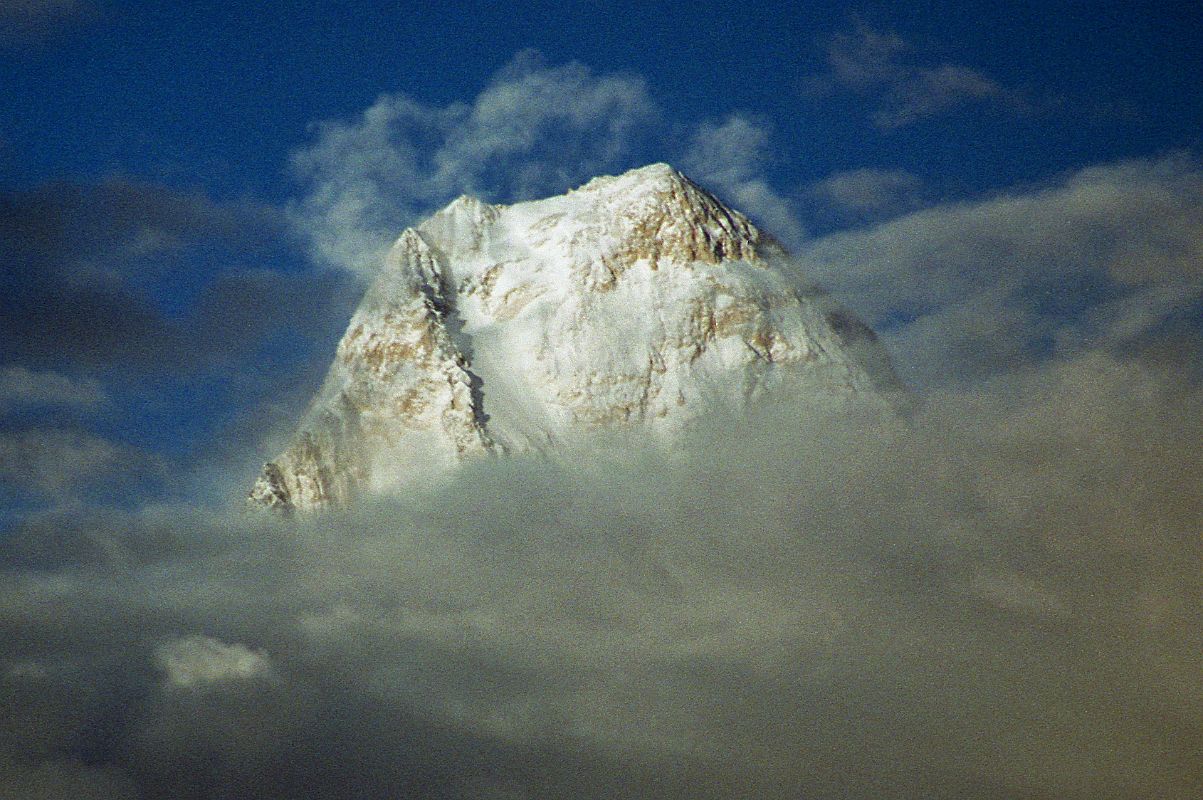 14 Gasherbrum IV Summit Peaks Out Of Clouds At Sunset From Goro II The West Face of Gasherbrum IV shines at sunset from Goro II. The first ascent of Gasherbrum IV was made via the northeast ridge on August 6, 1958 by famed Italian mountaineer Walter Bonatti and Carlo Mauri on a strong Italian team led by legendary climber Riccardo Cassin. A desperate struggle between the mountain and ourselves, but we were all winners, and at 12.30 exactly the little pennants of Italy, Pakistan and the C.A.I. fluttered on the Summit itself. Fluttered  no, blew out in the howling gale. - Karakoram: The Ascent Of Gasherbrum IV by Fosco Maraini.